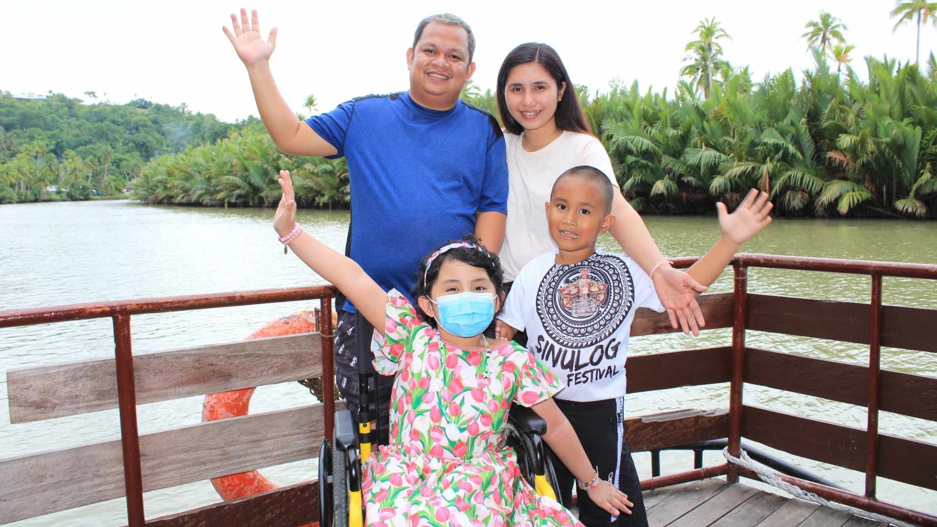 A family smiles together during an outdoor boat trip in the Philippines.