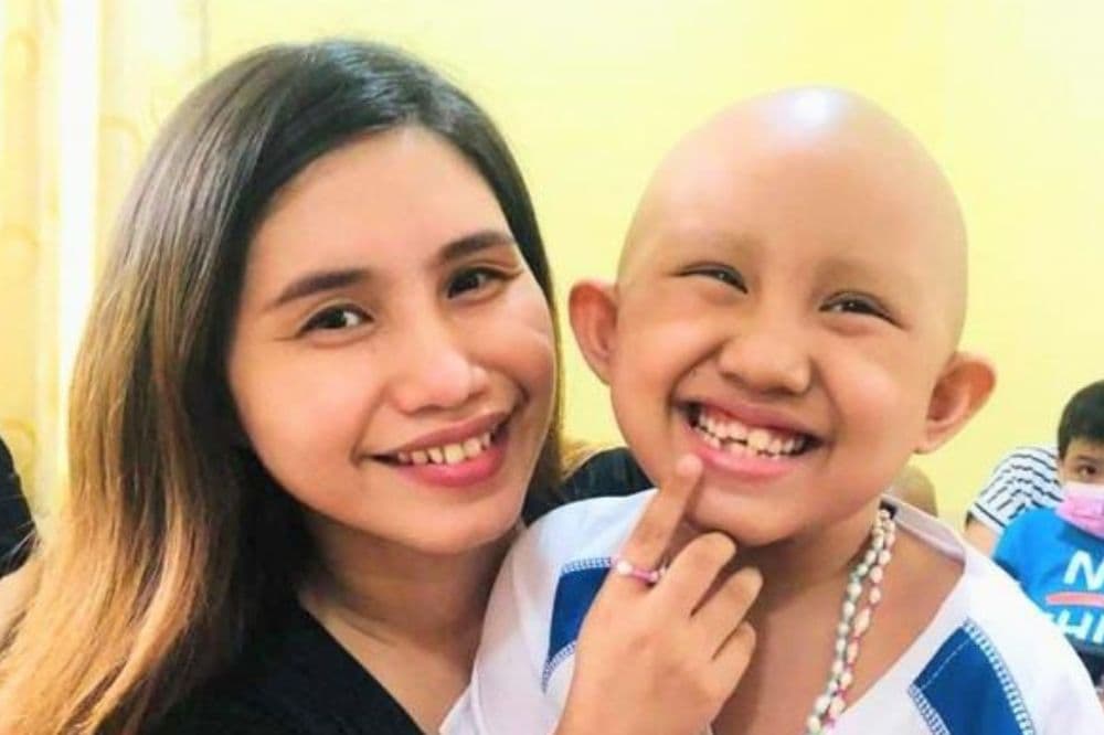Jane Manili stands beside a smiling caregiver.